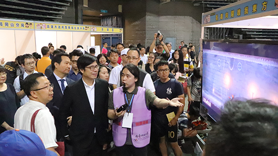 01南臺科大多樂系林敬博同學向行政院副院長陳其邁介紹學校參展遊戲軟體「畏光都市」。.jpg